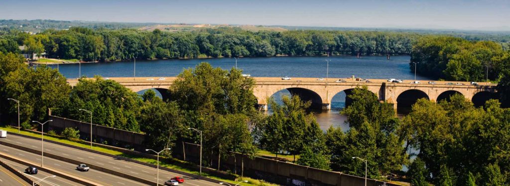 Highway beside a river and stone arch bridge in Connecticut