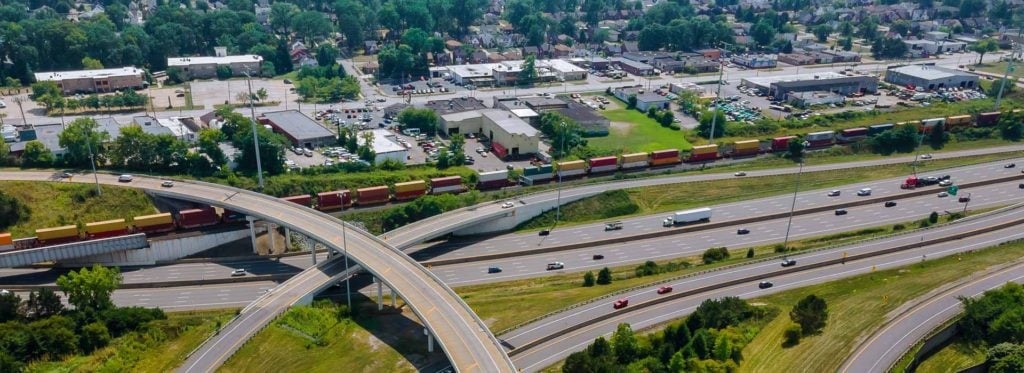 Freeway interchange beside a freight train and town in Ohio
